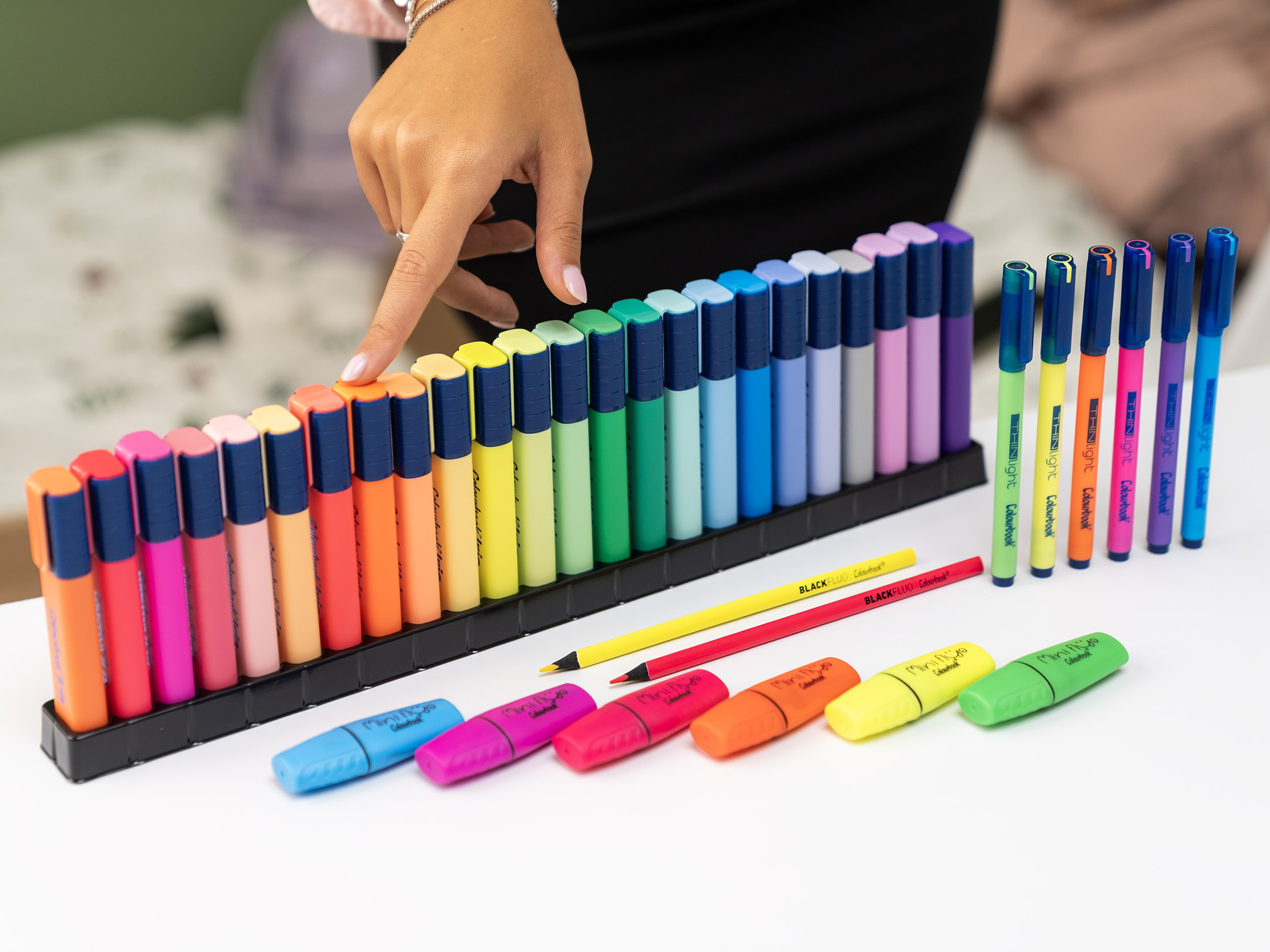 mix di evidenziatori su tavolo bianco evidenziatore in una lunga fila ordinata di Colourbook Iris, disposti in gradazione cromatica: dal rosso al giallo, fino ai blu, viola e pastello. Sul tavolo sono presenti anche: Evidenziatori singoli sparsi, pronti all’uso, in colori fluo e brillanti. Penne Colourbook in vari colori coordinati. Matite colorate gialla e rossa, che aggiungono un tocco essenziale e vivace. L’immagine comunica l’idea di scelta e organizzazione attraverso il colore: ogni sfumatura diventa uno strumento per personalizzare appunti, schemi e idee, rendendo più facile la memorizzazione e più piacevole lo studio o il lavoro.